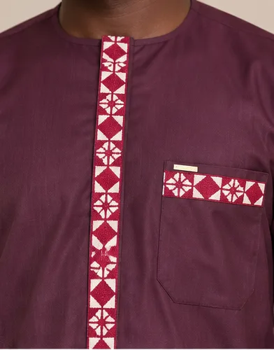 Détail de galon brodé sur tissu bordeaux